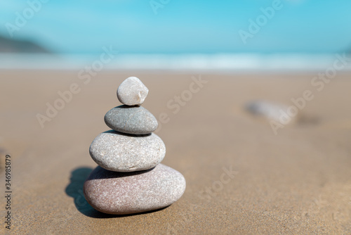 Pyramid of stones for meditation lying on sea coast. Five white stones tower. Simple poise stones. Simplicity harmony and balance  rock zen sculptures. Zen and relax concept.