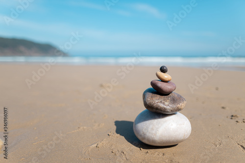 Pyramid of stones for meditation lying on sea coast. Five colored stones tower. Simple poise stones. Simplicity harmony and balance  rock zen sculptures. Zen and relax concept.  