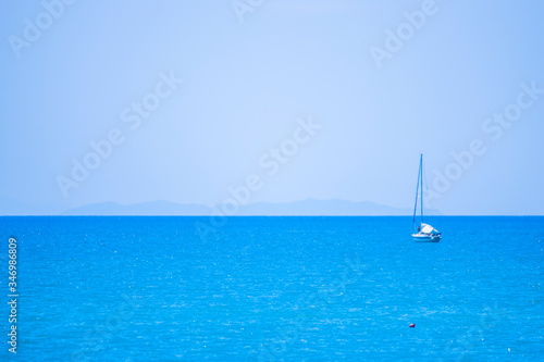 blue sea with white boat and island in the background