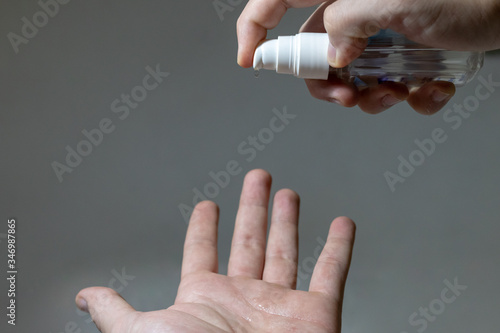 white-skinned hands putting alcohol gel on hands photo