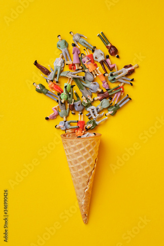 Fotografie toy figures of people and an ice cream cone on a yellow background