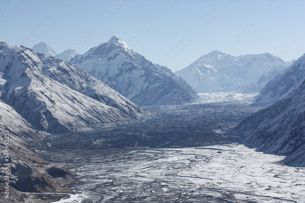 Mountain valley, the river and the body of the glacier in the February snow.