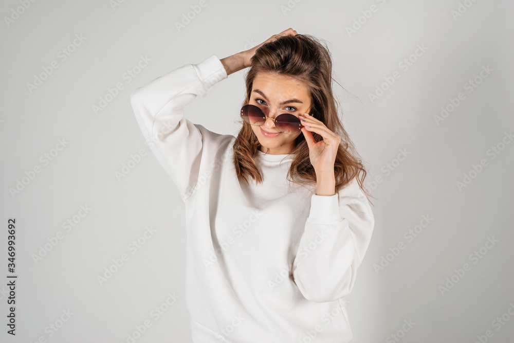 Young beautiful woman wearing sunglasses, studio shoot on white background Young beautiful woman wearing sunglasses, studio shoot on white background