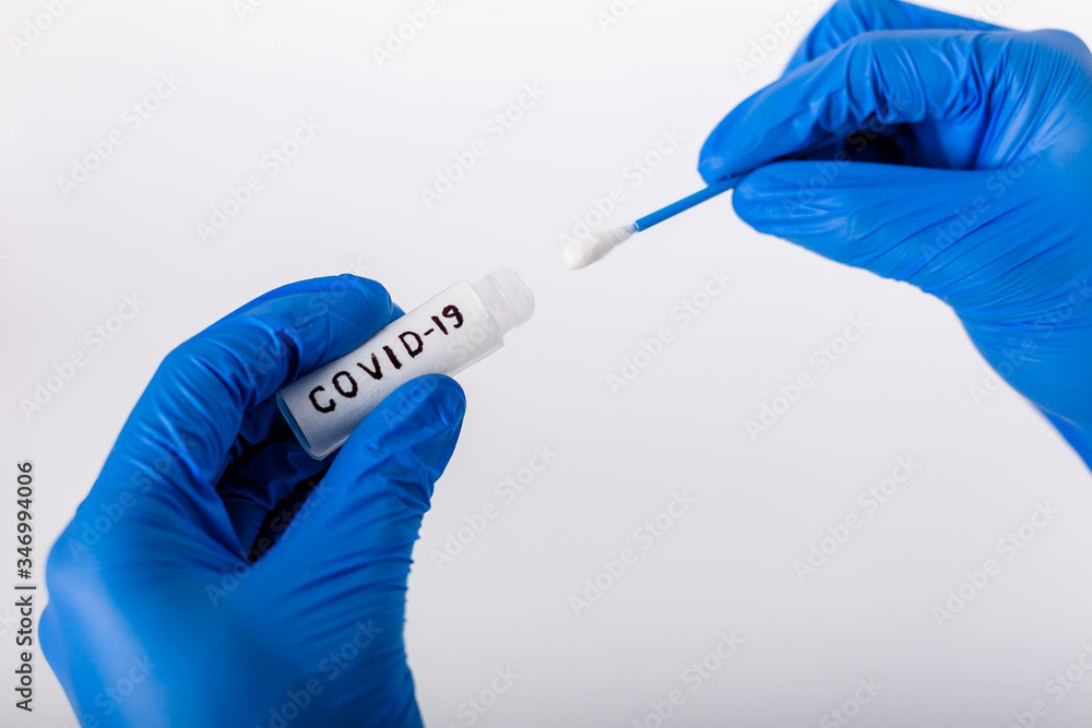 A healthcare professional takes a smear of COVID-19. In protective gloves. Test tube for analysis. Doctor with test tube for analysis and sampling of infection. Side view. White background. A healthcare professional takes a smear of COVID-19. In protective gloves. Test tube for analysis. Doctor with test tube for analysis and sampling of infection. Side view. White background.