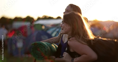 Joyful caucasian girls at camping site in strong backlight and vintage flare looking around in slow motion
