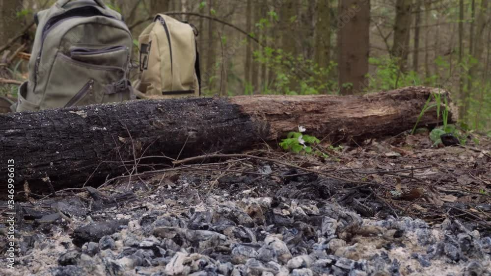 sausages and chicken eggs are fried in a pan. Nature in the woods on coals and a bonfire. Camping or hiking. Against the background of backpacks. sausages and chicken eggs are fried in a pan. Nature in the woods on coals and a bonfire. Camping or hiking. Against the background of backpacks.