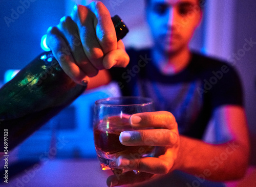 boy serving whiskey with blue and red lights