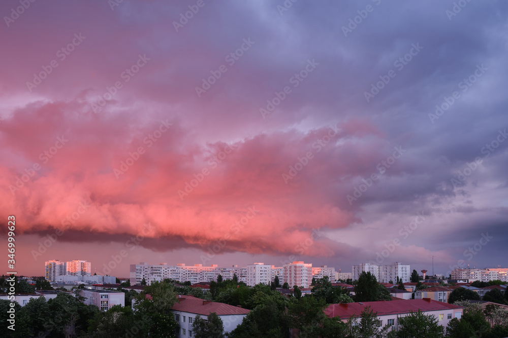 Pink and purple storm clouds at sunset, in Bucharest, Romania, contrasting with bright exterior buildings. Pink and purple storm clouds at sunset, in Bucharest, Romania, contrasting with bright exterior buildings.