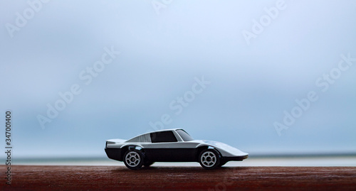Image of a White Racing Car on a blue bokeh background and wooden surface