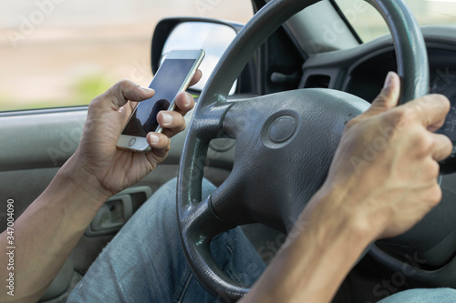 Distracted dangerous driver using a phone in the car.  Careless driving. © globalmoments