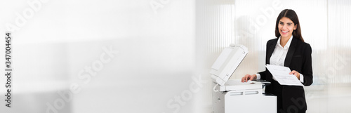 Fotografie Businesswoman Using Photocopy Machine In Office