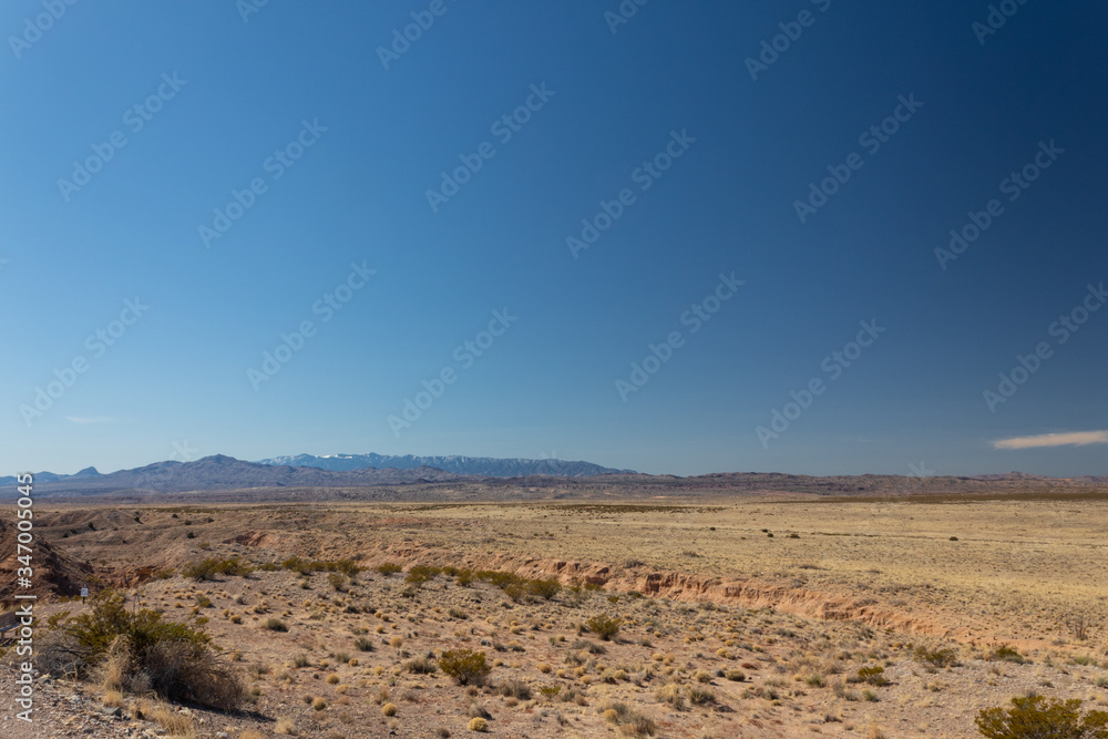 Glimpse of snow on a mountain ridge, New Mexico desert under brilliant blue sky, horizontal aspect