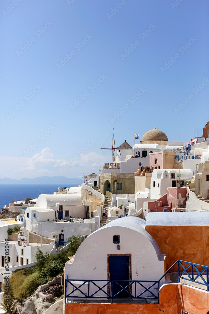 View of the city of Oia on the island of Santorini in Greece. white houses, mill, Aegean sea, resort, summer