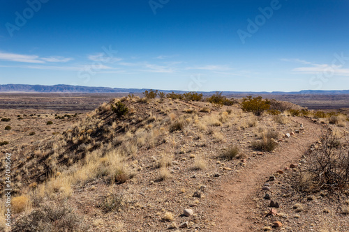 Dirt path running along the top of a ridge in the Chihuahuan desert of New Mexico, road less traveled, blue sky copy space, horizontal aspect