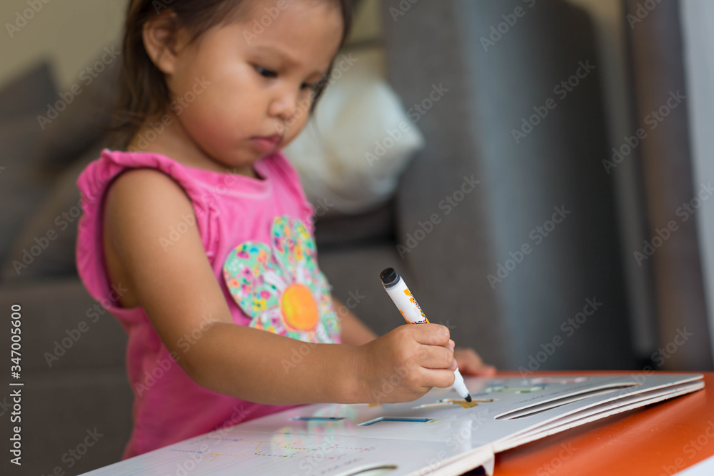 Little kid learning how to write the alphabet letters. Children education at home. Little kid learning how to write the alphabet letters. Children education at home.