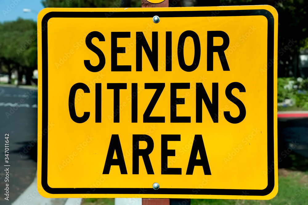 Yellow traffic sign that says Senior Citizens Area with graphic of senior citizens walking Yellow traffic sign that says Senior Citizens Area with graphic of senior citizens walking