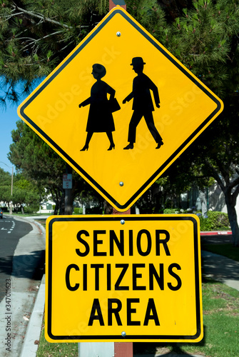 Yellow traffic sign that says Senior Citizens Area with graphic of senior citizens walking photo