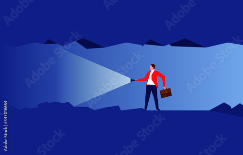 Businessman holding a flashlight to explore inside a dark cave