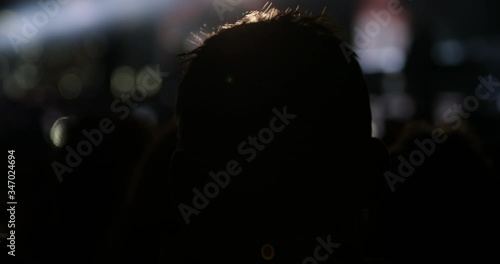 Silhouette of young adult in the dark at music festival