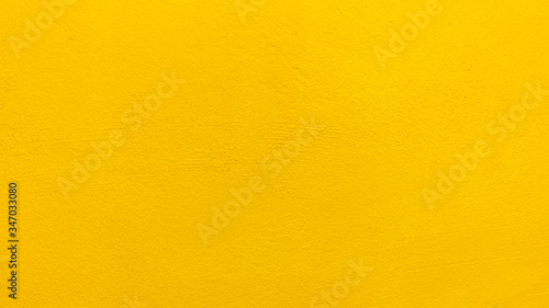 Blurred Yellow stucco wall background. Yellow painted cement wall texture.