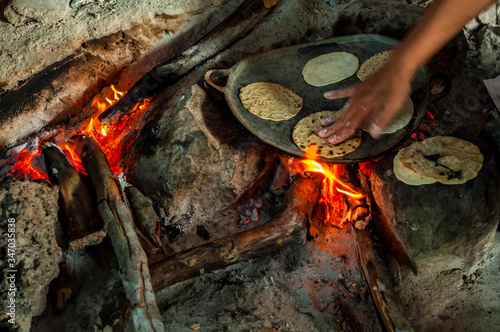Preparación de tortillas caseras en fogón tradicional de vivienda en Yucatán, México. photo