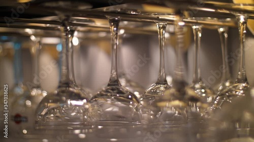 Empty Wine Glasses Hang Above A Bar Rack