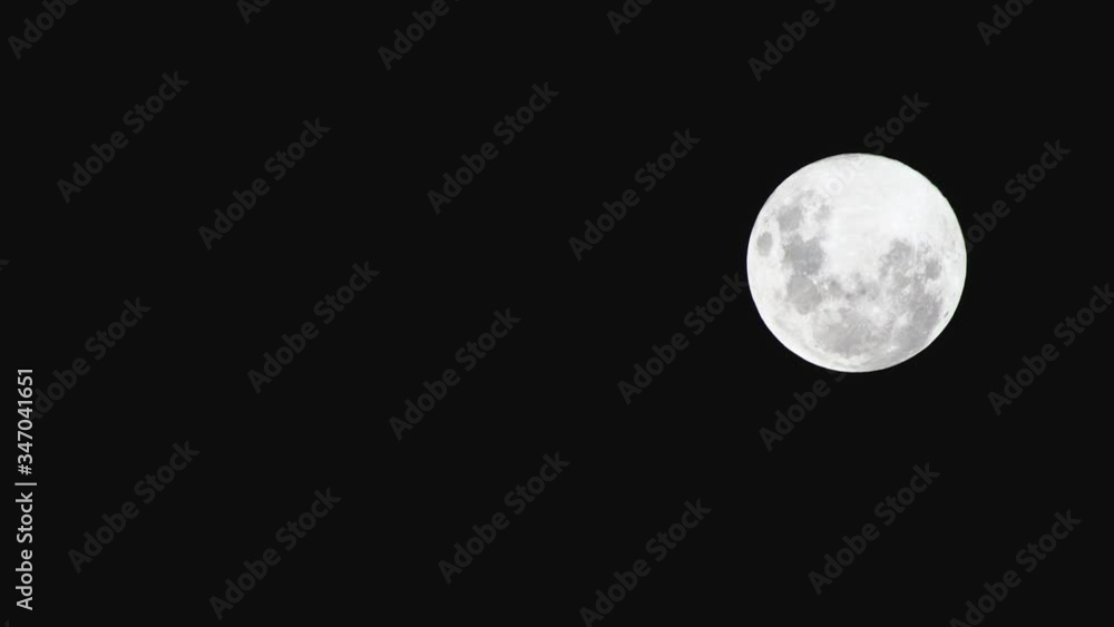 full moon in the night sky moving across the frame with camera panning horizontally full moon in the night sky moving across the frame with camera panning horizontally