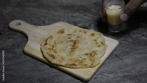 Roti and sweetened condensed milk on a wooden table, roti cananai or roti, knead the dough by roti with oil Traditional Indian street food, handmade roti
