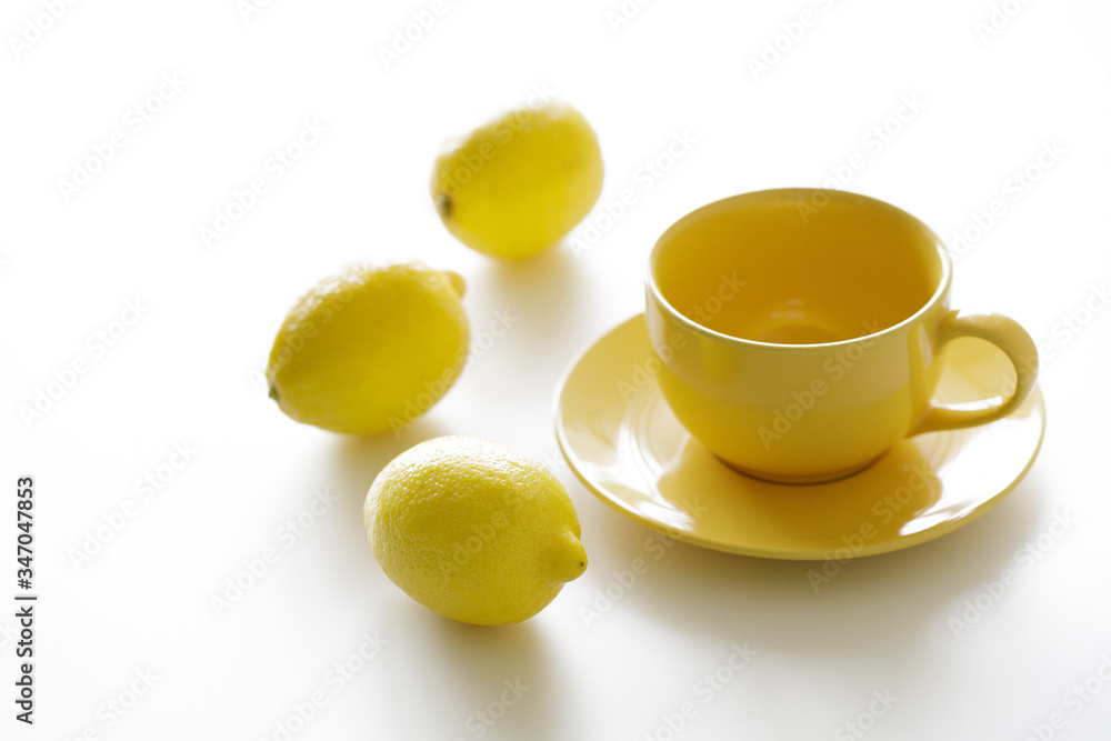 cup of tea with fresh yellow lemons on white background