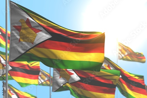 Fototapeta Naklejka Na Ścianę i Meble -  wonderful day of flag 3d illustration. - many Zimbabwe flags are wave against blue sky image with soft focus