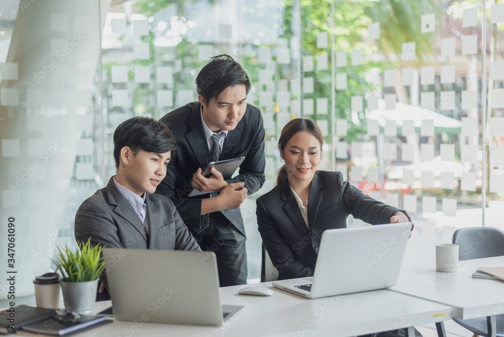 Young asian business people meeting and planning business strategies together in the office. Young asian business people meeting and planning business strategies together in the office.