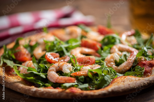 Pizza covered with roquette and shrimps
