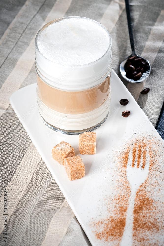 Glass Cup of coffee latte macchiato or cappuccino with foam on a dark background serving on the table Glass Cup of coffee latte macchiato or cappuccino with foam on a dark background serving on the table
