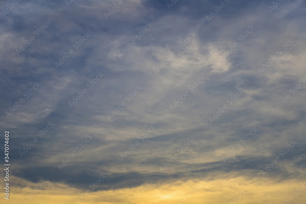 The image of a beautiful sky with thick clouds covered the bottom of the picture with the golden light from the sun.