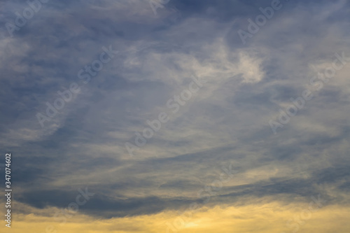 The image of a beautiful sky with thick clouds covered the bottom of the picture with the golden light from the sun.