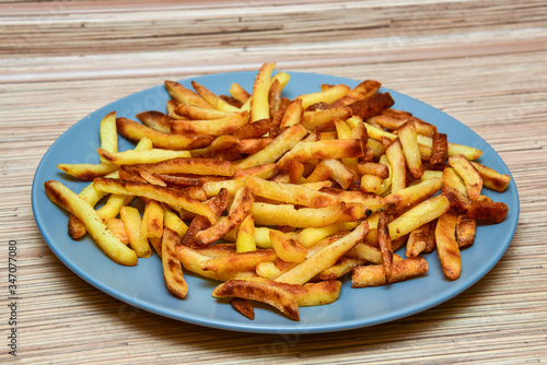 french fries on a blue plate on a wooden background