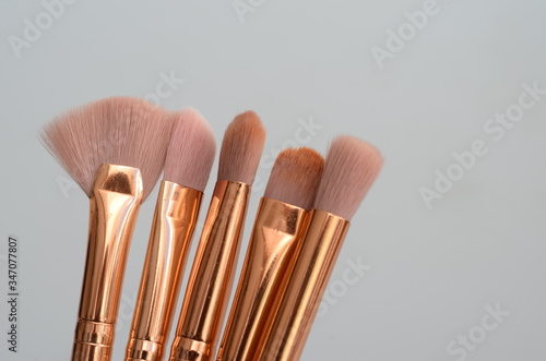 several pink and gold makeup brushes