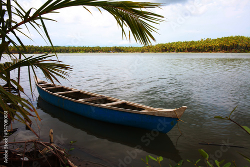 Lonely canoe on the riverbanks of Ponoor puzha. Aesthetic view of the Kerala beauty  depicting the elegance  serenity and harmony of the nature.