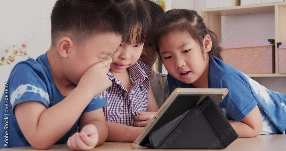 Group of children looking to tablet together. Education, Study, Technology and Lifestyle concept. Group of children looking to tablet together. Education, Study, Technology and Lifestyle concept.