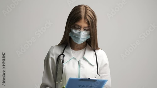 Doctor in a medical gown shows a folder with the text stay at home photo