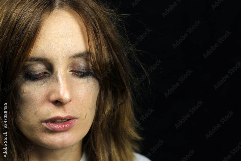 crying girl with smeared mascara on a black background crying girl with smeared mascara on a black background