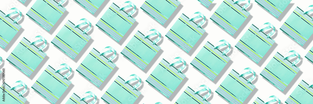 Top view of turquoise paper shopping bag pattern on trendy pink background. Copy space. Creative design for packaging. Gift concept. Woman's day. Valentine's day. Ready for birthday party. Top view of turquoise paper shopping bag pattern on trendy pink background. Copy space. Creative design for packaging. Gift concept. Woman's day. Valentine's day. Ready for birthday party.
