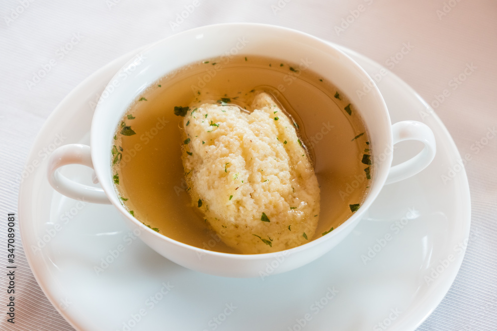 Semolina Dumpling Soup, Beef Broth with Parsley in a White Bouillon Cup, a Specialty of Austrian and Viennese Cuisine Semolina Dumpling Soup, Beef Broth with Parsley in a White Bouillon Cup, a Specialty of Austrian and Viennese Cuisine