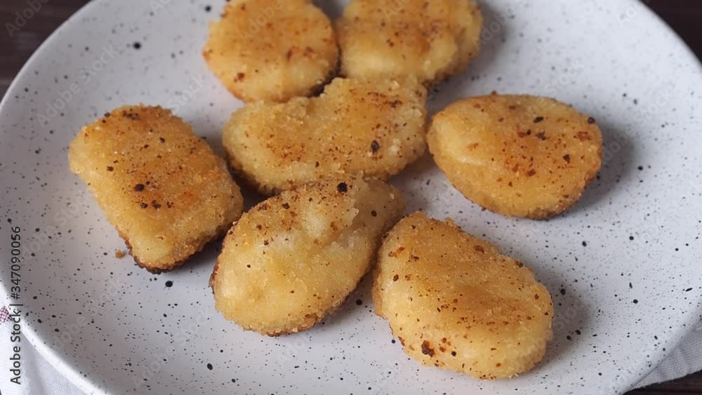 Fried chicken nuggets are placed on a plate. Close up. Concept of unhealthy fast food nutrition. Fried chicken nuggets are placed on a plate. Close up. Concept of unhealthy fast food nutrition.