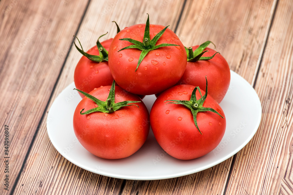 Raw ripe pink heirloom organic tomatoes on wooden background. Vegetarian - Vegan healthy diet culinary cooking concept - Top View Raw ripe pink heirloom organic tomatoes on wooden background. Vegetarian - Vegan healthy diet culinary cooking concept - Top View