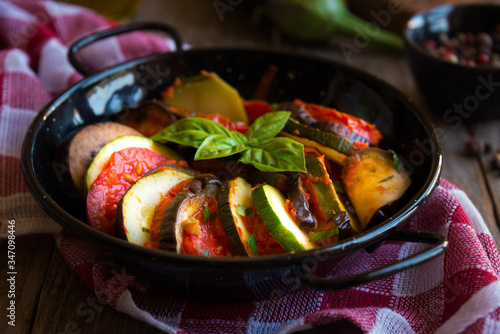 Homemade ratatouille made with sliced vegetables: zucchini, tomatoes and eggplant. Delicious vegan dish