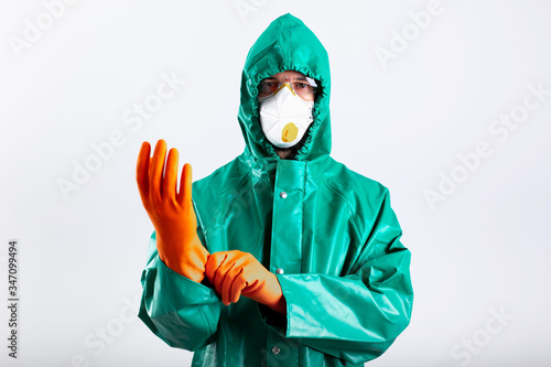 Man pulling his rubber glove while standing against the white background