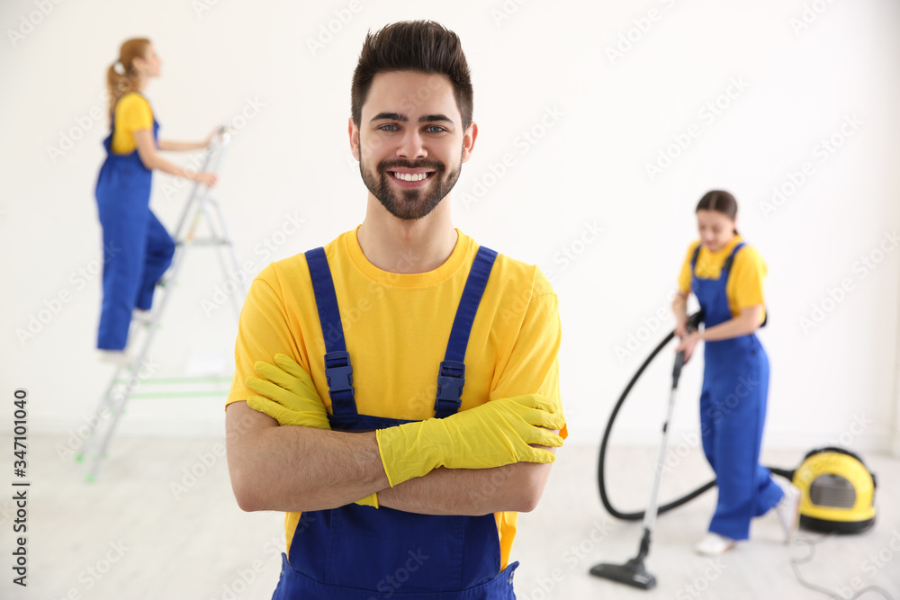 Professional janitor in uniform indoors. Cleaning service Professional janitor in uniform indoors. Cleaning service