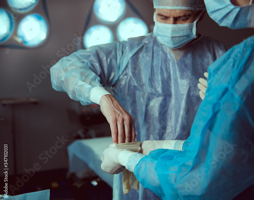 Experienced doctor preparing with nurse for operation