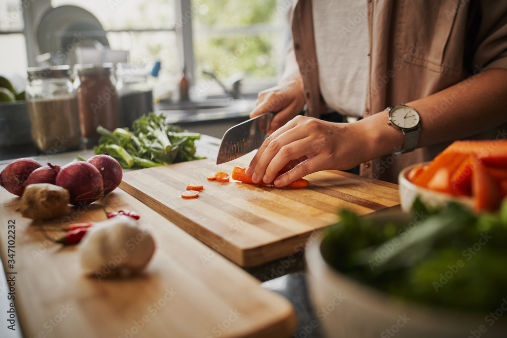 © StratfordProductions - Closeup of young female hands chopping fresh orange carrot on board while in modern kitchen - healthy food to boost the immune system © StratfordProductions - Closeup of young female hands chopping fresh orange carrot on board while in modern kitchen - healthy food to boost the immune system